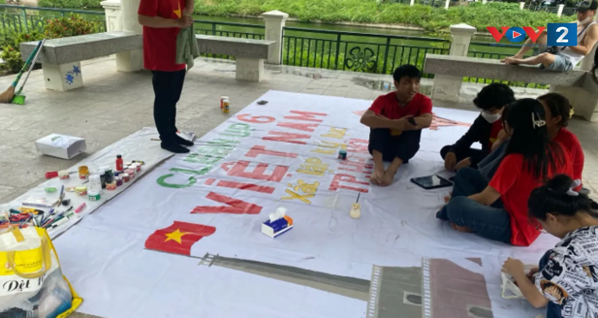 Các tình nguyện viên đang tập trung trang trí các tấm băng rôn khẩu hiệu từ vật liệu tái chế